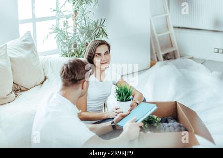 heureux couple assis sur le canapé dans un nouvel appartement. Banque D'Images