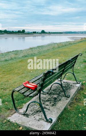 Paire de chaussures rouges sur le banc de stationnement. Banque D'Images