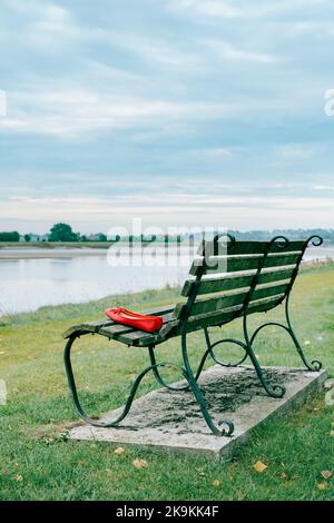 Paire de chaussures rouges sur le banc de stationnement. Banque D'Images