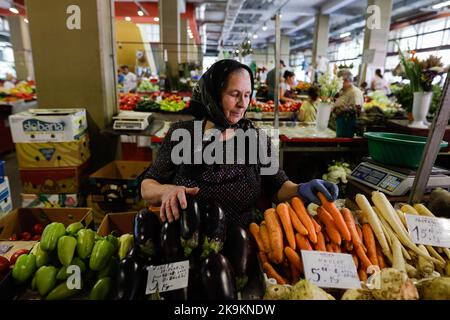 Bucarest, Roumanie - 4 août 2022: Faible profondeur de champ (foyer sélectif) détails avec une femme senior vendant des légumes sur un stand dans le marché d'Obor Banque D'Images