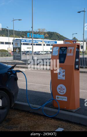 Bruyères, France - 22 octobre 2022 : un cliché statique d'un double moteur noir solide Tesla modèle 3 chargé à la station de charge c.a. E.Leclerc dans une autu ensoleillée Banque D'Images