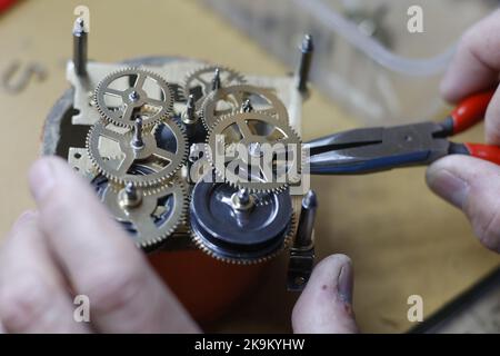 28 octobre 2022, Saxe-Anhalt, Gernrode: Le maître horloger Uwe Bergmann met en mouvement le mouvement d'une horloge à coucou dans les salles de musée de l'ancienne usine d'horloge de Harz à Gernrode. Environ 300 horloges coucou différentes et d'autres expositions sont présentées ici sur 800 mètres carrés. Le musée de l'horloge comprend également un espace d'atelier où les pendules à coucou et autres mouvements de l'horloge sont réparés avec soin. L'attraction principale du musée est la plus grande horloge à coucou en dehors de la Forêt Noire avec une hauteur de 14,50 mètres. Le dernier dimanche d'octobre commence la période d'hiver. Dans la nuit à partir du samedi Banque D'Images