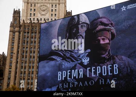 Moscou, Russie. 29th octobre 2022. Une bannière publicitaire patriotique est vue sur fond de bâtiment en hauteur du ministère des Affaires étrangères dans le centre de Moscou, en Russie. La bannière lit « le temps des héros nous a choisis » Banque D'Images