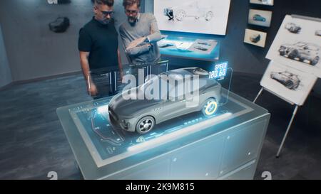 Deux ingénieurs de développement. Tester les performances de vitesse d'une voiture électrique écologique de pointe avec des normes durables à l'aide d'un bureau de réalité augmentée holographique avancé. Banque D'Images