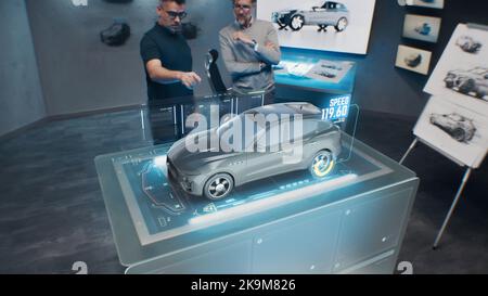 Deux ingénieurs de développement. Tester les performances de vitesse d'une voiture électrique écologique de pointe avec des normes durables à l'aide d'un bureau de réalité augmentée holographique avancé. Banque D'Images