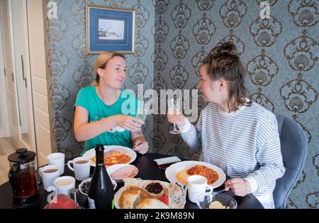 Saint-Pétersbourg, Russie, 2021 août : les jeunes femmes en pyjama célèbrent et boivent du champagne dans des verres en cristal sur la bruderschaft. Banque D'Images