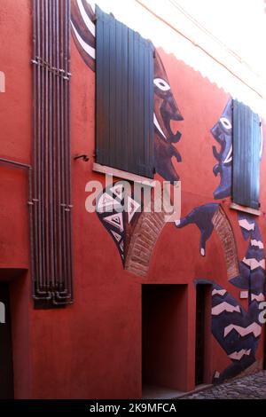 Dozza, Italie. Peintures murales sur la façade des bâtiments historiques. 'Deux femmes bavardant', par Kamil Tarqosz. Banque D'Images