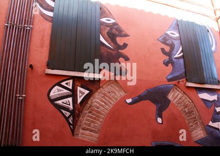 Dozza, Italie. Peintures murales sur la façade des bâtiments historiques. 'Deux femmes bavardant', par Kamil Tarqosz. Banque D'Images