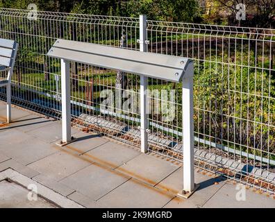 Banc incliné ou support incliné ou barre maigre (pas encore de nom établi) - nouveau remplacement moderne de banc traditionnel sur les gares de chemin de fer, bus ou tramwa Banque D'Images