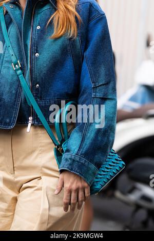 Milan, Italie - 21 septembre 2022 : femme portant une veste en Jean bleu et vert à motif d'impression de teinture, grand pantalon beige, cuir bleu vert tressé Banque D'Images