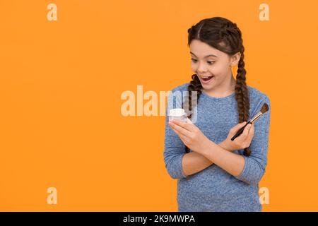 Aimez-vous plus. Concept de soin de la peau. Application de maquillage sur une peau saine. Produits de maquillage pour enfants. Espace de copie. studio de photo de fille faisant le maquillage Banque D'Images