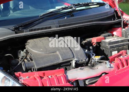 Petite voiture avec capot ou capot ouvert révélant le moteur. Banque D'Images