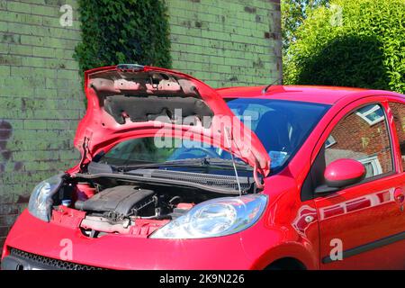 Petite voiture avec capot ou capot ouvert révélant le moteur. Banque D'Images