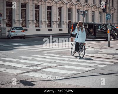 Vienne, Autriche - juin 2022 : une blonde à vélo dans les rues de Vienne. Cycliste au feu Banque D'Images
