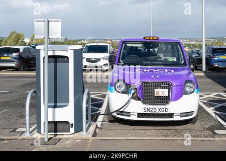 Taxi électrique à un point de recharge de véhicule électrique à Ingliston Park and Ride, Newbridge, Édimbourg, Écosse, Royaume-Uni Banque D'Images