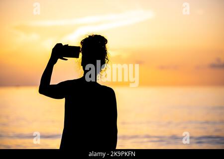 Hollywood Beach à Miami, Floride lever ou coucher de soleil le matin avec chemin de réflexion, femme prenant photo selfie photographie avec l'appareil photo de téléphone Banque D'Images