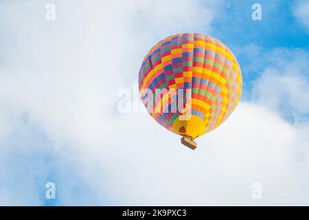 Ballon à air chaud coloré à motifs volant sur le ciel bleu ciel nuageux au-dessus de la ville turque de Cappadoce. Sports extrêmes et expériences en voyage. Photo de haute qualité Banque D'Images