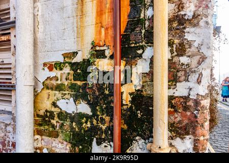 Une section de mur abîmée et usée avec de la peinture écaillée et rend j'ai besoin de réparation. Banque D'Images