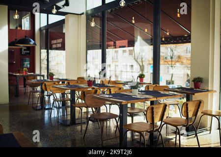 Encore tôt dans la journée. Un restaurant vide rempli de tables et de chaises à l'intérieur pendant la journée. Banque D'Images