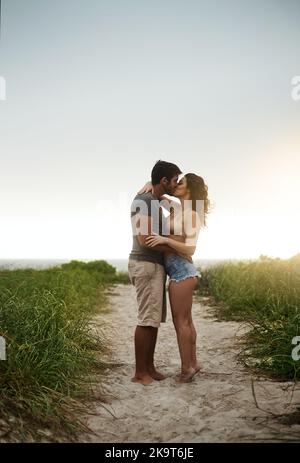 Savourez chaque moment de romantisme. Un jeune couple passe une journée romantique à la plage. Banque D'Images