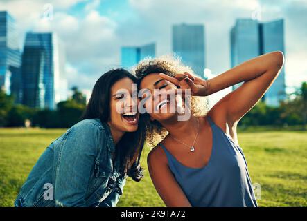 Amitié, rire et paix. Portrait court de deux amies joyeuses dans un parc. Banque D'Images