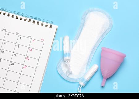 Calendrier menstruel. Calendrier avec blocs et tampons sur fond bleu. Banque D'Images