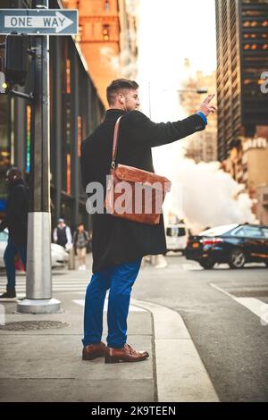 Que dois-je faire pour faire un tour ici. Un jeune homme joyeux qui écoute de la musique pendant qu'il essaie de signaler un taxi pour se rendre au travail dans les plus occupés Banque D'Images