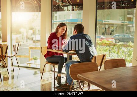 Leur première date allait très bien. Un jeune homme et une jeune femme à une date romantique dans un café. Banque D'Images