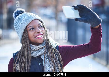 Voici la neige et les selfies. Une belle jeune femme qui prend un selfie lors d'une journée enneigée en plein air. Banque D'Images