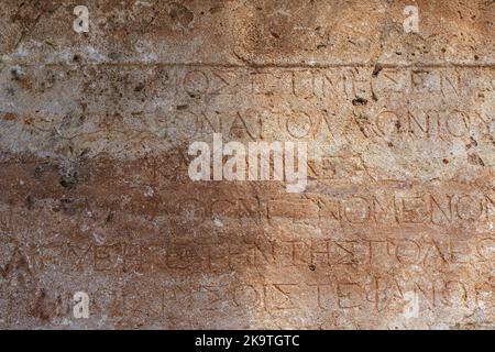 Texte antique grec antique et inscriptions sur le mur en pierre du temple. Culture grecque ancienne, alphabet et écriture de fond, concept d'histoire. Photo de haute qualité Banque D'Images