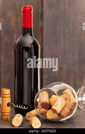 Bouteille de vin rouge, verre à vin avec bouchons à vin et tire-bouchon sur table en bois. Le concept de vin de boisson. Banque D'Images