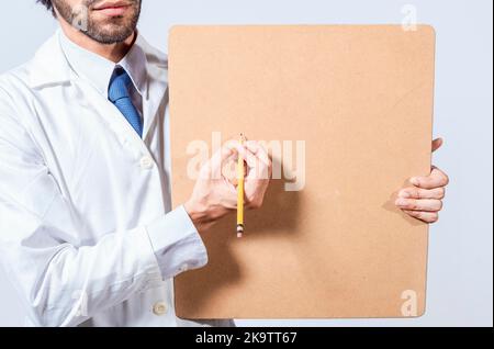 Mains du médecin avec crayon montrant le tableau de notes avec espace de copie. Médecin écrivant et montrant un tableau de notes avec un espace pour le texte. Médecin concept écrit sur Banque D'Images