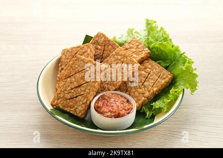 Tempeh, Tempe Goreng ou Fried tempeh est un aliment traditionnel indonésien, fait à partir de graines de soja fermentées. Servi avec de la sambal (sauce Chili) Banque D'Images