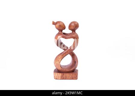 Figurine en bois symbole de l'amour isolée sur fond blanc. Sculpter l'artisanat humains statuette avec l'homme et la femme embrassant Banque D'Images