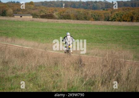 Un cycliste à moteur (motard) qui fait rouler sa moto tout-terrain le long d'une piste de pierre sur la plaine de Salisbury, dans le Wiltshire Banque D'Images