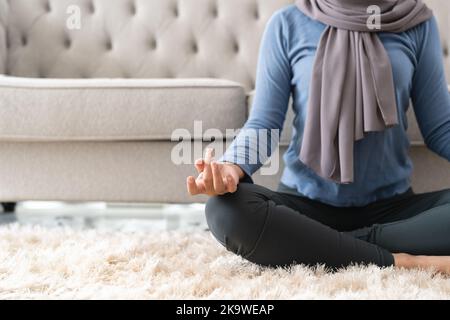 Concept de gestion du stress. Gros plan paisible jeune femme dans hijab méditant à la maison Banque D'Images