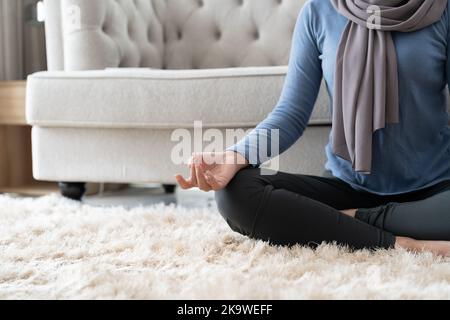 Concept de gestion du stress. Gros plan paisible jeune femme dans hijab méditant à la maison Banque D'Images