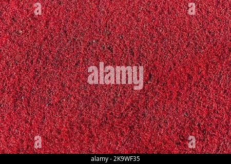 Texture de fond synthétique en plastique rouge, utilisée sur les aires de jeux pour enfants et comme pelouse de gym et aussi terrains de sport, phot Banque D'Images