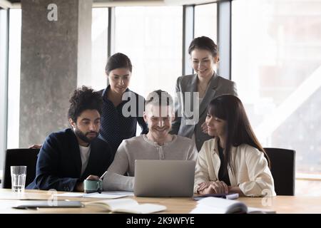 Groupe d'hommes d'affaires multiethniques travaillant ensemble sur ordinateur portable Banque D'Images