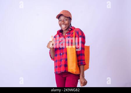 Portrait d'une jeune femme africaine excitée tenant la main sac de shopping isolé sur fond blanc Banque D'Images