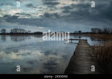 Jetée en bois sur le lac et ciel nuageux Banque D'Images