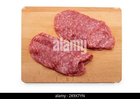 Tranches de salami, tranches de saucisse de salami italien sur un panneau de coupe en bois isolé sur blanc, chemin d'écrêtage Banque D'Images