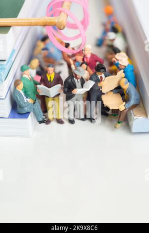 Jouet miniature de passagers lisant le journal et les gens voyagent du travail sur un concept de transport public - Voyage dans un train ou un bus. Banque D'Images