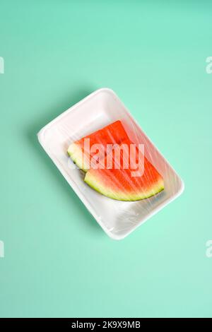 tranches de pastèque fraîches enveloppées dans un emballage en plastique, image verticale Banque D'Images