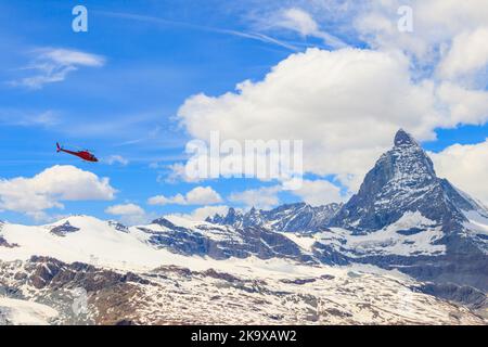 Hélicoptère survolant le sommet enneigé de Matterhorn, Suisse Banque D'Images
