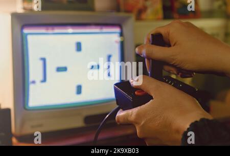 Femme jouant à l'ancienne console rétro avec joystick. Banque D'Images