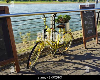 Vélo jaune décoratif sur la promenade du Rhin à Düsseldorf, en Allemagne. Banque D'Images