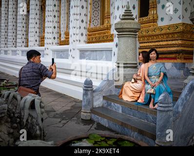 Deux femmes vietnamiennes touristes vêtues de costumes traditionnels thaïlandais loués posent pour des photos à Wat Arun à Bangkok, Thaïlande. Banque D'Images