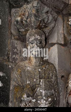 Début du martyr chrétien Saint Just, un garçon âgé de seulement sept ans exécuté par les Romains en Espagne. Statue de pilier dans le portail nord de la Basilique Saint-Just à Valcabrère, Occitanie, France. Au-dessus de la face de St Just, une capitale romane sculptée dépeint dans des détails assez horribles la décapitation de Just et de son frère de 13 ans, Pasteur, pour avoir dénoncé la religion romaine. Banque D'Images