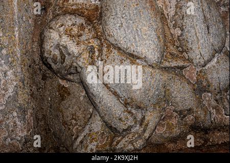 Le mal se mange sous les pieds d'un jeune enfant chrétien martyr alors que des monstres aux visages semi-humains dévorent les queues de l'autre. Sculpture romane fin 1100s sous la statue de pilier à Saint Pastor vieux de 13 ans dans le portail nord de la basilique romane Saint-Just fin 1100s, consacrée en 1200 après J.-C. à Valcabrère, Occitanie, sud-ouest de la France. Banque D'Images